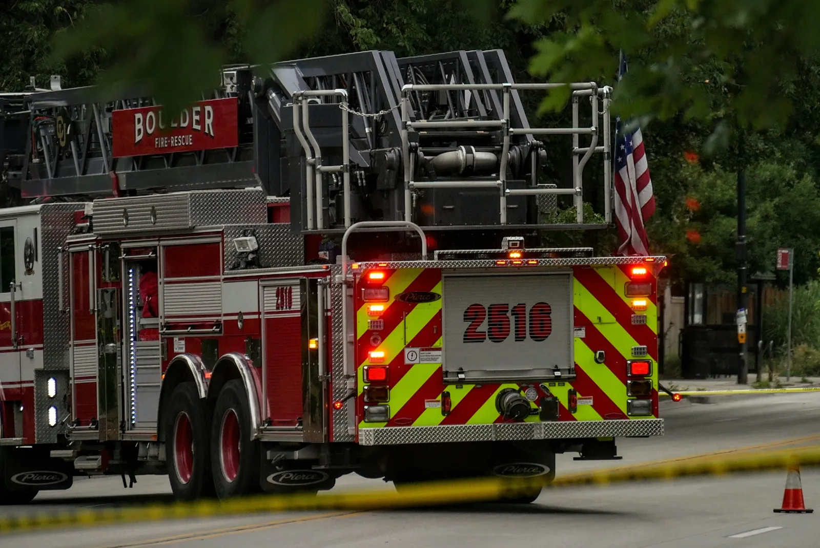 Aerial ladder fire truck with its ladder folded, parked on a city street